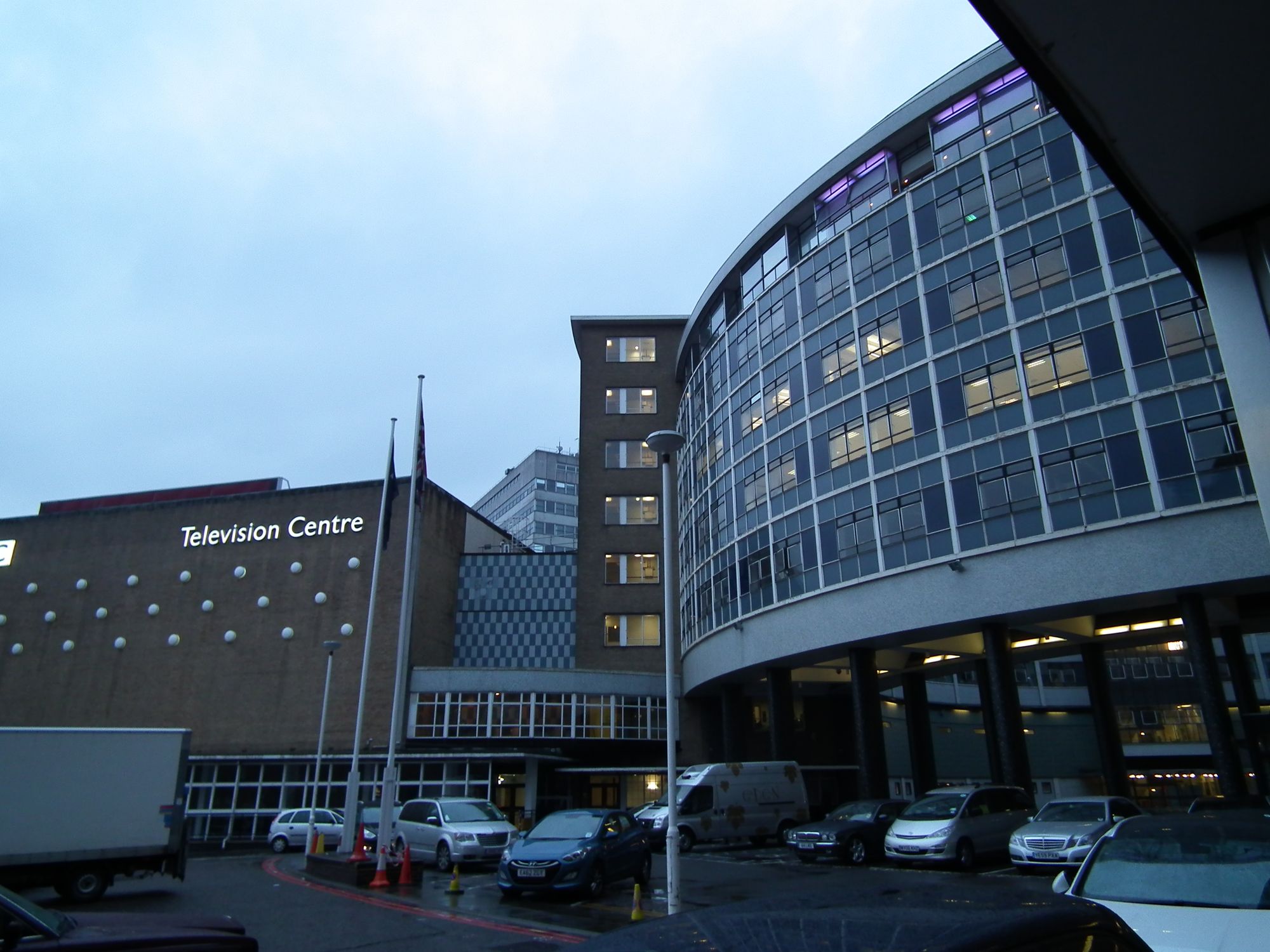 The iconic frontage of Television Centre: the curved outer wall of the doughnut, and on the left, the tall, windowless wall of the side of Studio 1.