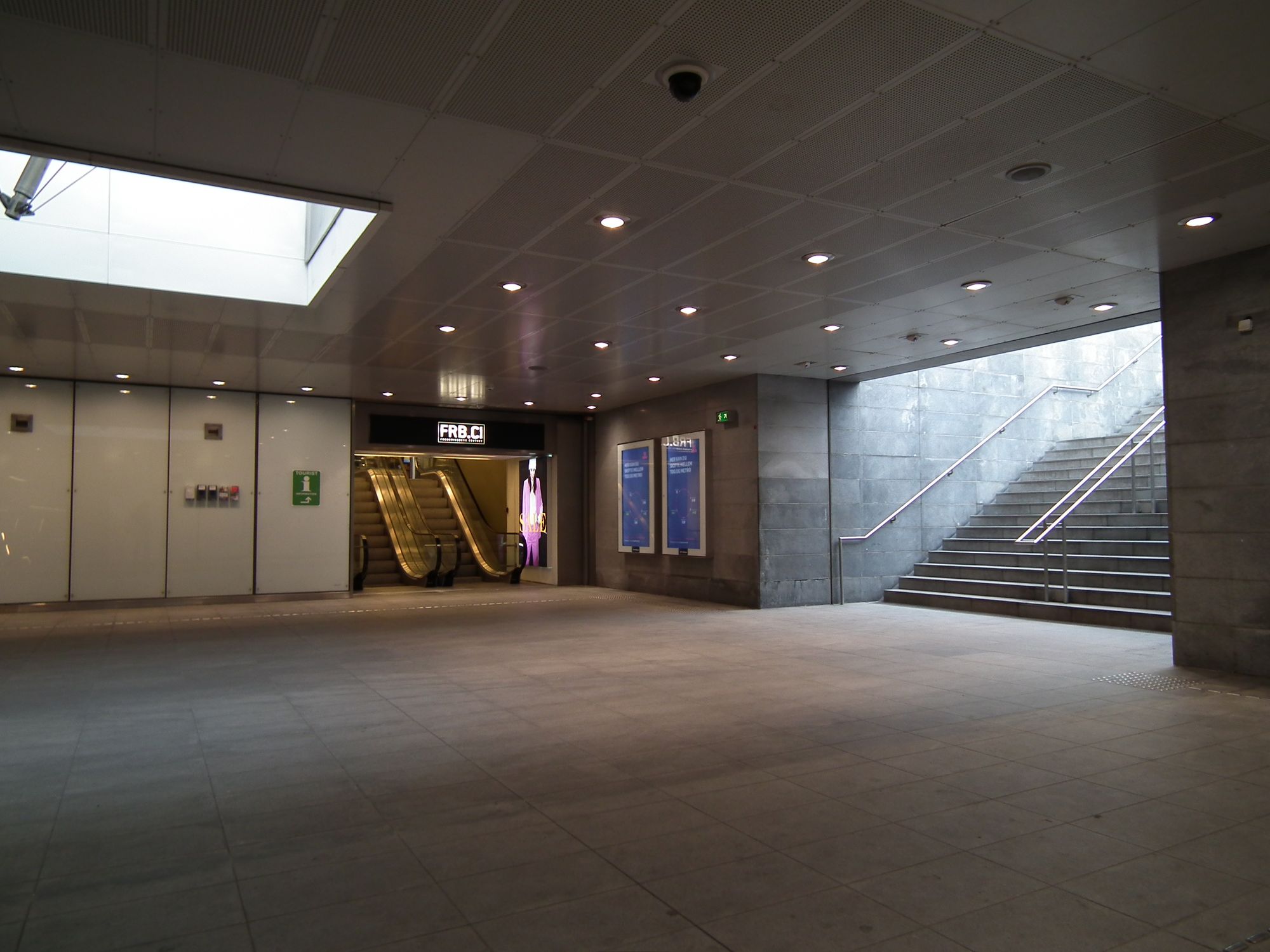 Reverse angle of the previous image, showing the short escalators up to the shopping centre, and the stairs up to the street, and daylight.