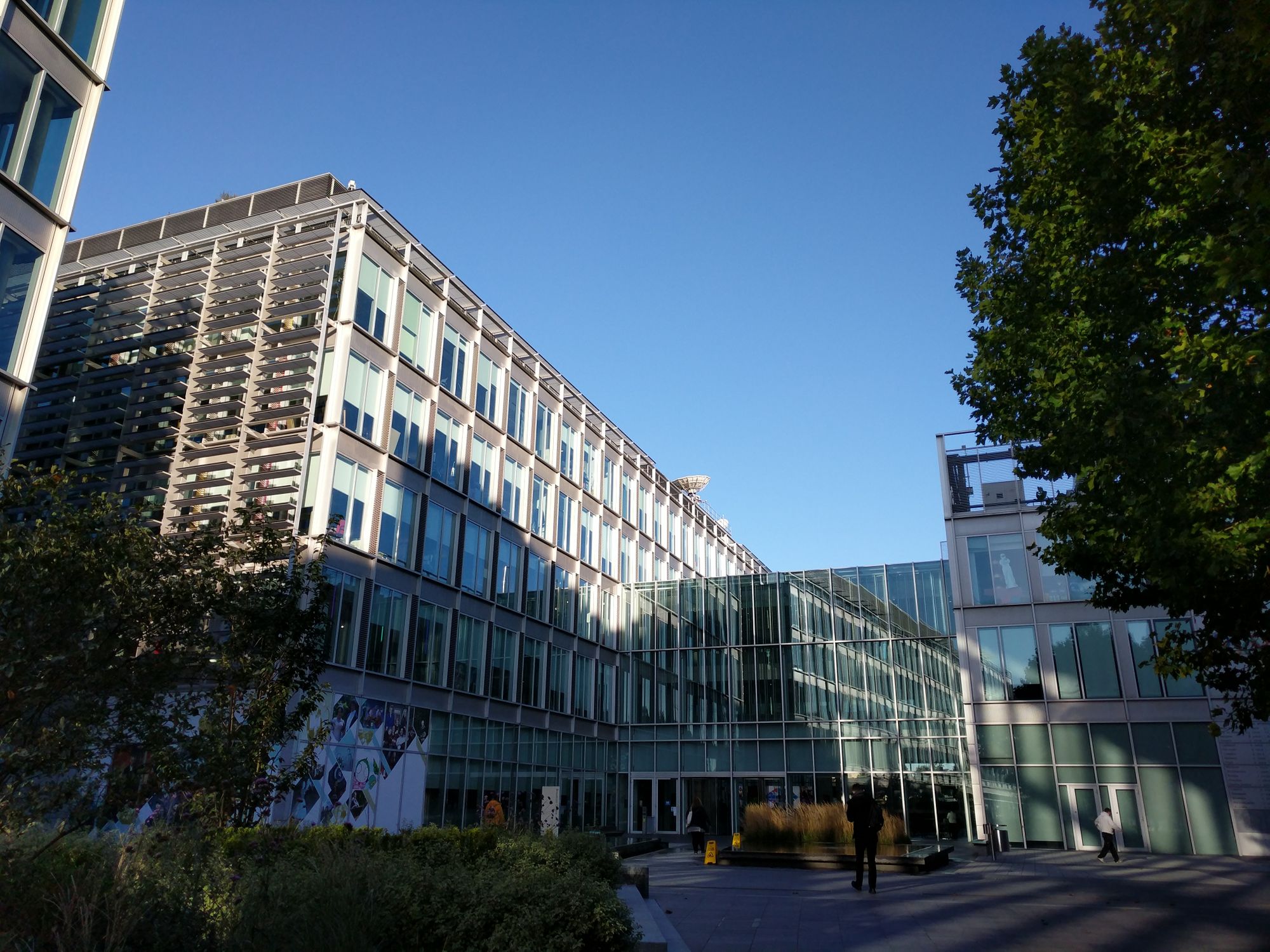 BBC Broadcast Centre, London W12: my workplace. It's a 6-storey glass and steel kind of building. It's a lovely sunny day, not a cloud in the sky. We can see a satellite dish on the roof of the building, and other buildings in similar style to the left and right.